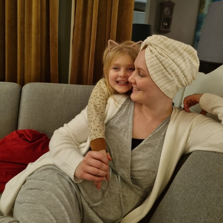 Ung kvinne med turban og datter i sofa